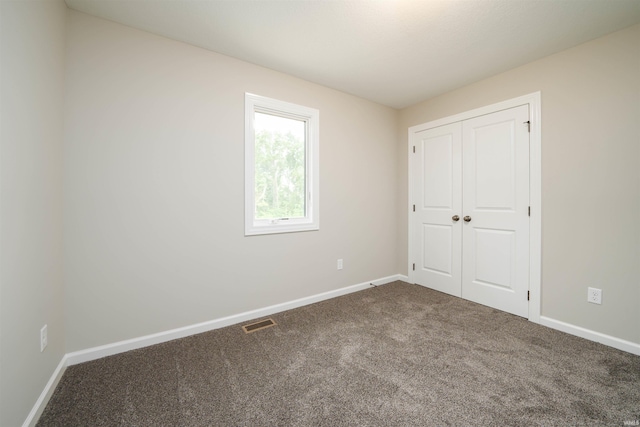 unfurnished bedroom with visible vents, baseboards, and carpet flooring