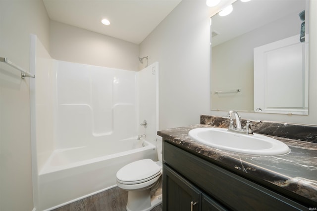 full bath with tub / shower combination, toilet, wood finished floors, and vanity