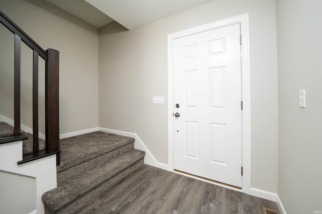 entryway featuring stairway, wood finished floors, and baseboards