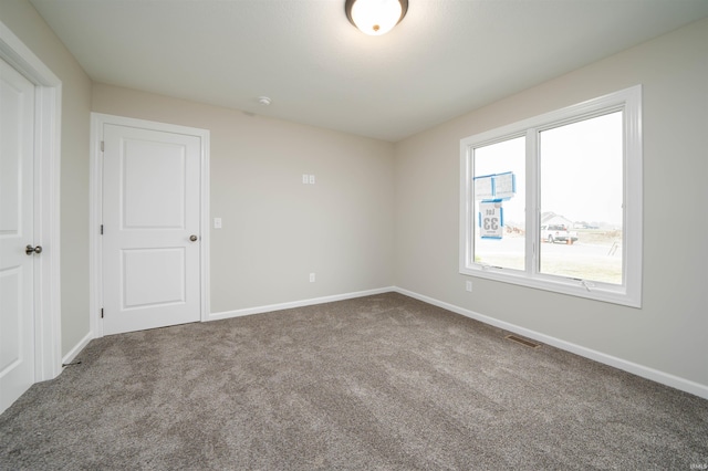 spare room with visible vents, baseboards, and carpet floors