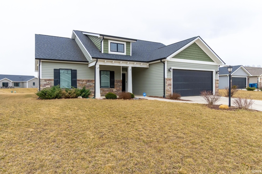 2165 Freestone Pl, Huntertown, IN 46748 - craftsman-style home featuring driveway, stone siding, an attached garage, and a front lawn