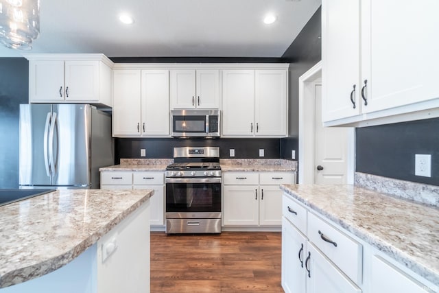 kitchen featuring dark wood-type flooring, light stone countertops, recessed lighting, appliances with stainless steel finishes, and white cabinets