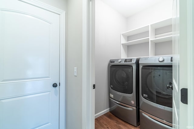 laundry room with washer and dryer, dark wood finished floors, and laundry area