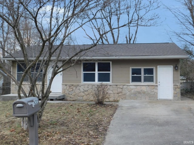 ranch-style house with stone siding and a shingled roof