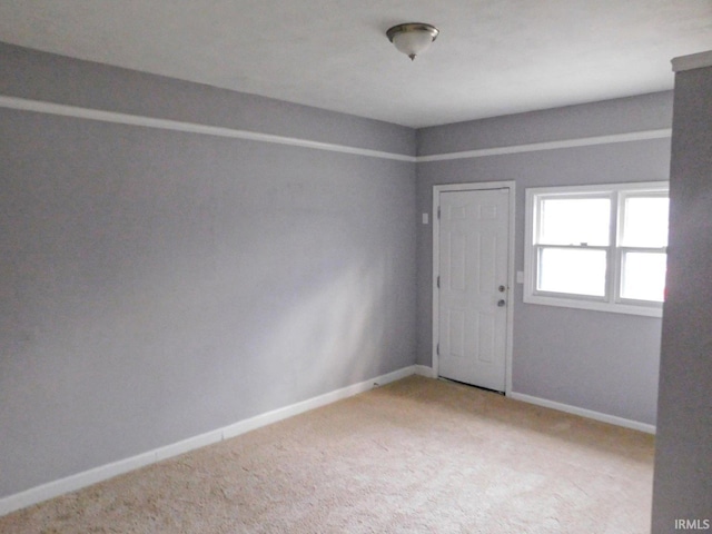 unfurnished room featuring baseboards and carpet floors