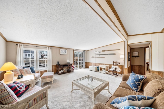 carpeted living area with a textured ceiling, crown molding, wooden walls, and wainscoting