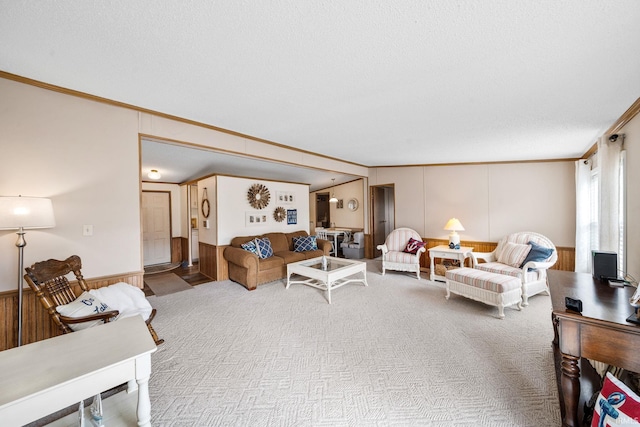 carpeted living room featuring wainscoting and crown molding