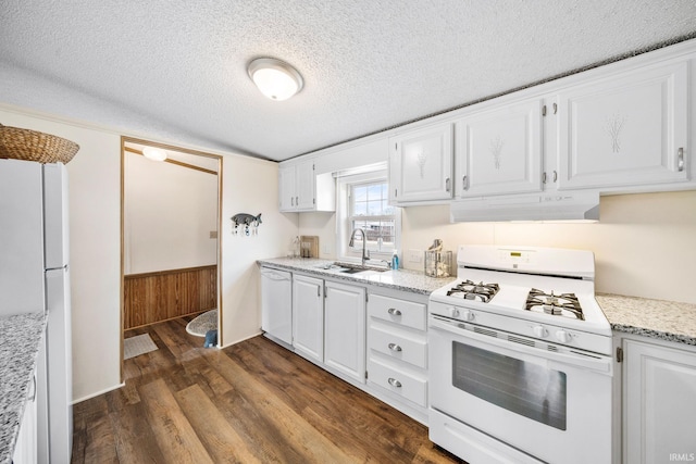 kitchen featuring under cabinet range hood, a sink, dark wood-style floors, white appliances, and white cabinets