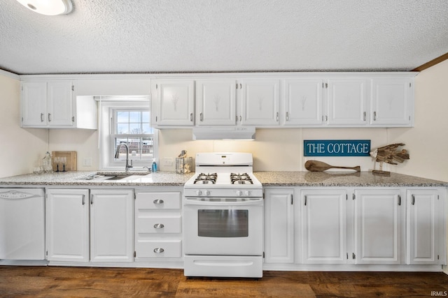 kitchen with white appliances, range hood, a sink, white cabinets, and a textured ceiling