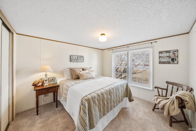 bedroom featuring carpet, crown molding, and a textured ceiling