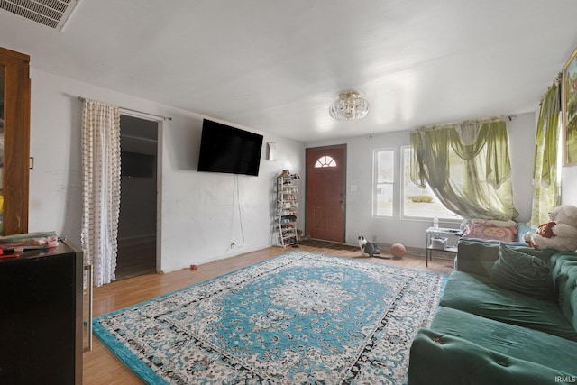 living area with visible vents and wood finished floors