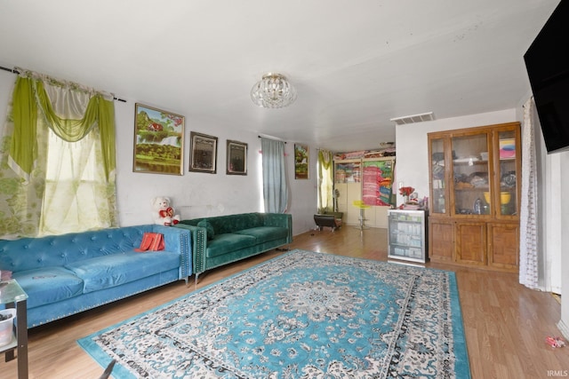 living area featuring visible vents and wood finished floors