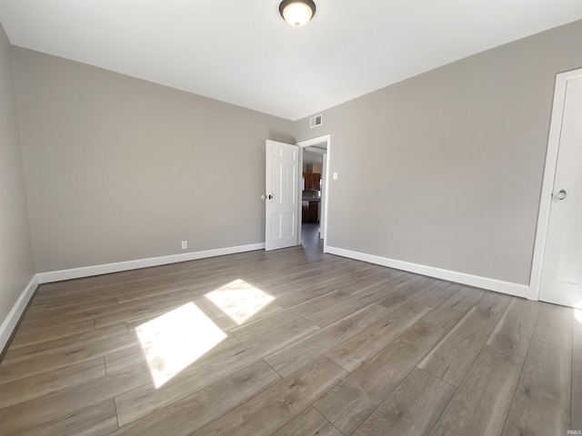 unfurnished bedroom featuring visible vents, baseboards, and wood finished floors