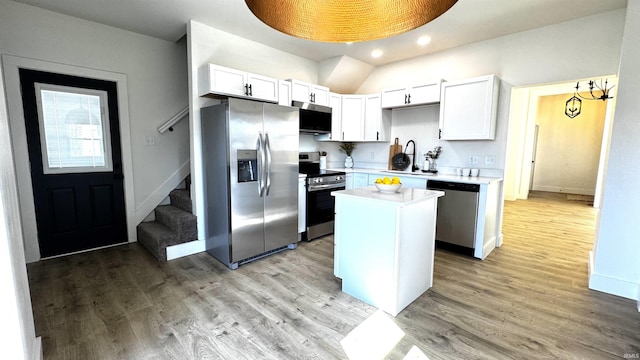 kitchen featuring a kitchen island, a sink, light countertops, light wood-style floors, and appliances with stainless steel finishes