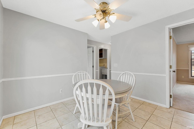 dining room featuring light tile patterned floors, ceiling fan, and baseboards