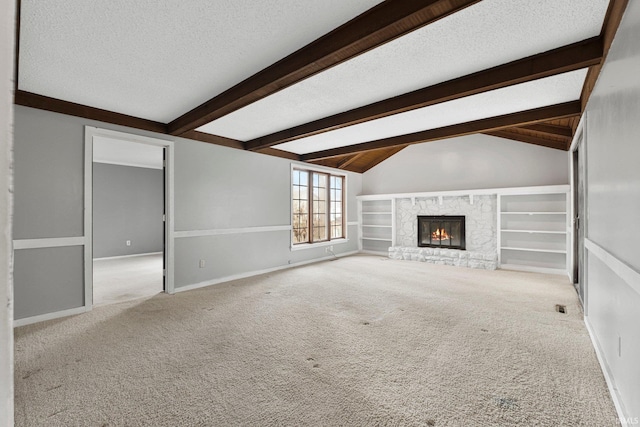 unfurnished living room with a stone fireplace, a textured ceiling, lofted ceiling with beams, and carpet floors