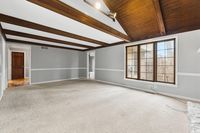 unfurnished room with lofted ceiling with beams, visible vents, carpet floors, and baseboards