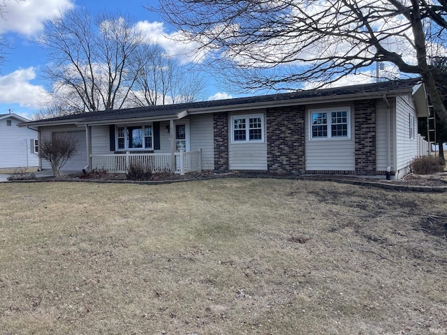 single story home with a porch, an attached garage, brick siding, and a front lawn