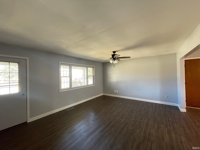 interior space featuring visible vents, baseboards, dark wood-type flooring, and a ceiling fan