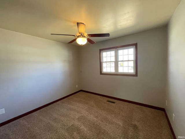 spare room with visible vents, carpet flooring, baseboards, and ceiling fan