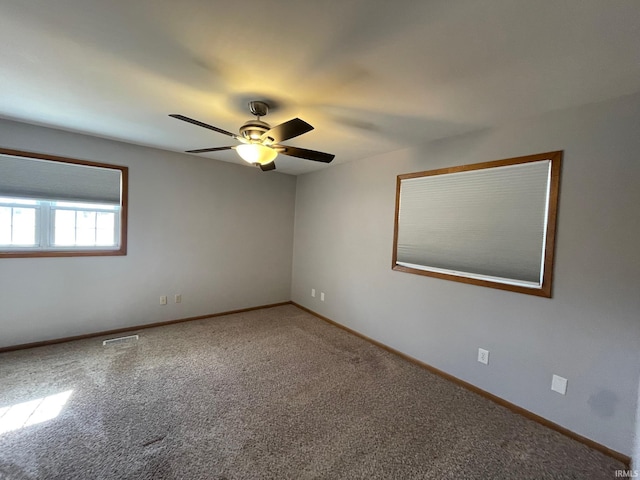 empty room featuring visible vents, baseboards, ceiling fan, and carpet flooring