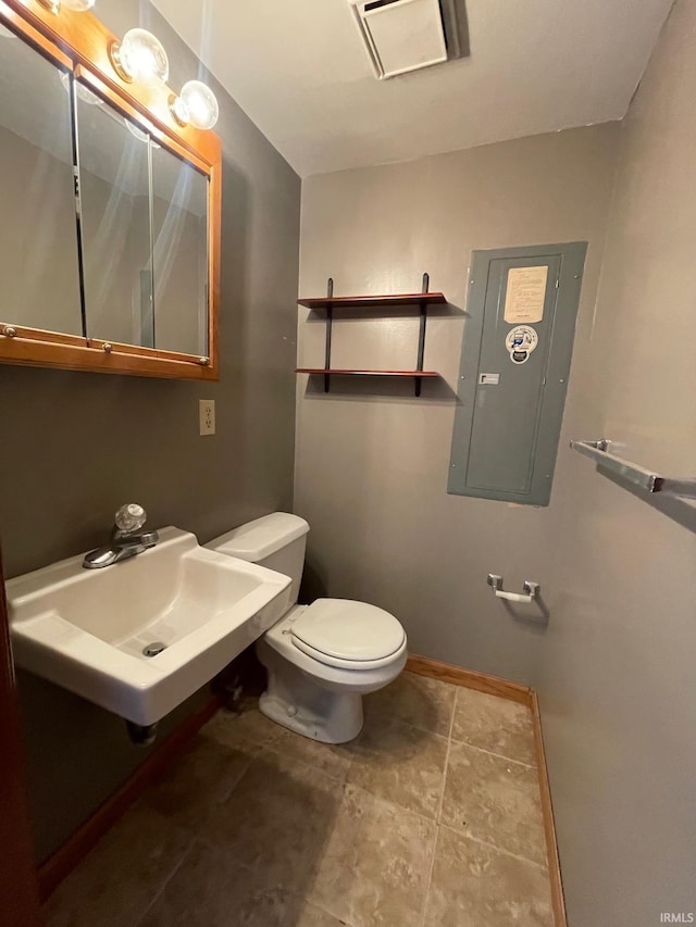 half bath with electric panel, baseboards, toilet, and a sink