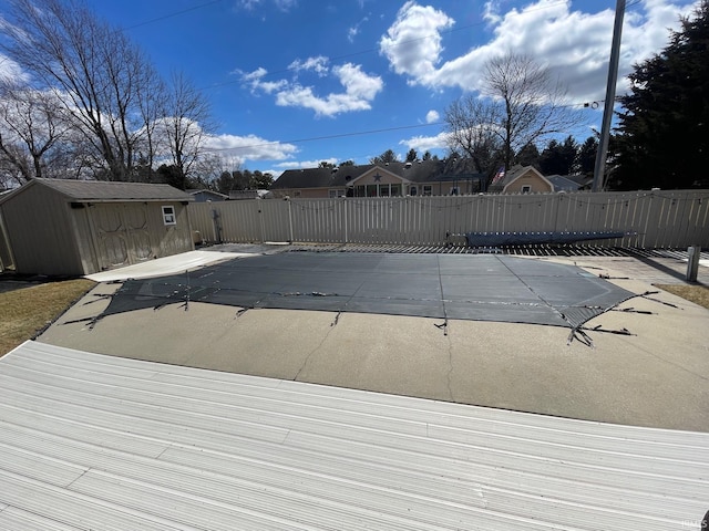 view of swimming pool with an outbuilding, fence, a shed, a fenced in pool, and a patio area