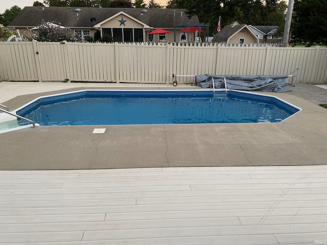 view of swimming pool featuring a patio, fence, and a fenced in pool