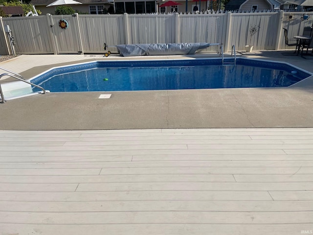 view of swimming pool with a patio area, a fenced in pool, and fence