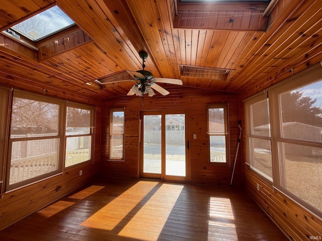 unfurnished sunroom featuring lofted ceiling with skylight, a healthy amount of sunlight, wood ceiling, and ceiling fan