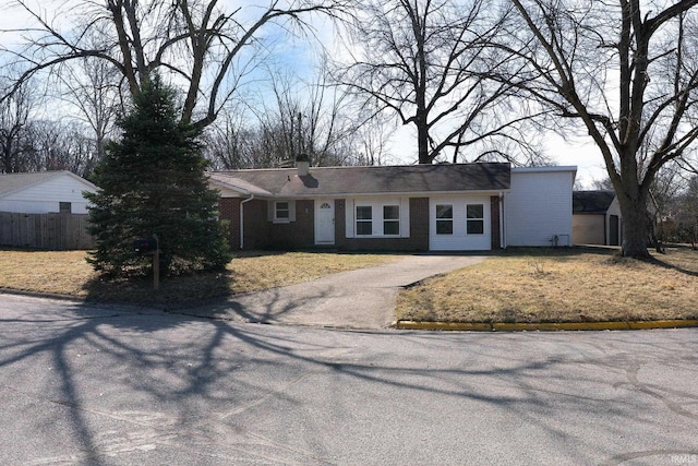 ranch-style house with brick siding, driveway, a front yard, and fence