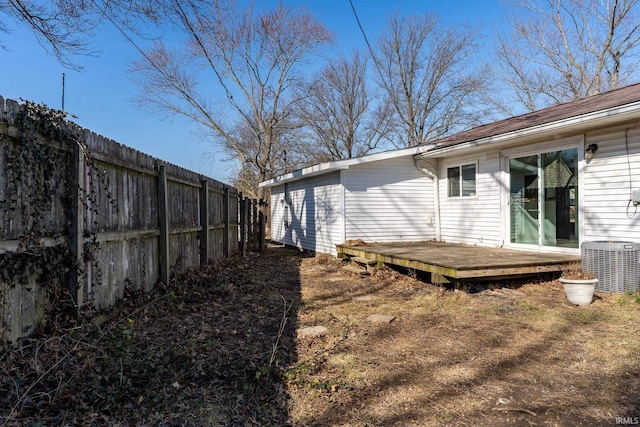 view of yard featuring central AC unit, a deck, and fence