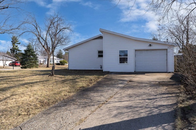 view of side of property featuring concrete driveway, a yard, and a garage