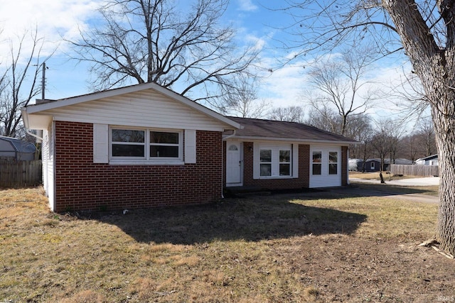 ranch-style house with brick siding, a front lawn, and fence