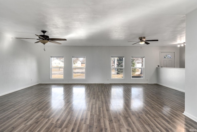 unfurnished living room featuring baseboards, dark wood-style floors, and a ceiling fan