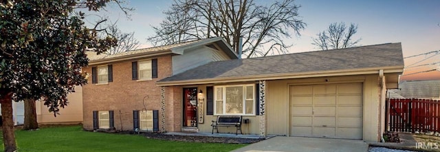 view of front of home with fence, concrete driveway, a front lawn, a garage, and brick siding