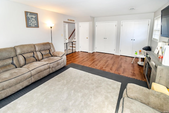 living area with wood finished floors and stairs