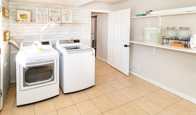 washroom featuring visible vents, independent washer and dryer, wood walls, light tile patterned floors, and laundry area