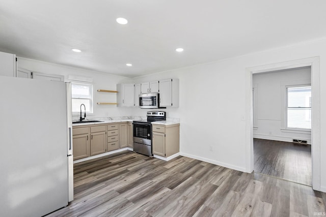 kitchen with a sink, open shelves, baseboards, appliances with stainless steel finishes, and dark wood-style flooring