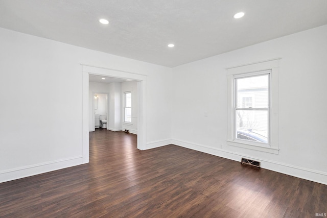 empty room featuring recessed lighting, visible vents, baseboards, and dark wood-type flooring