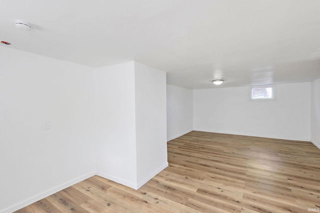 below grade area with light wood-style flooring and baseboards