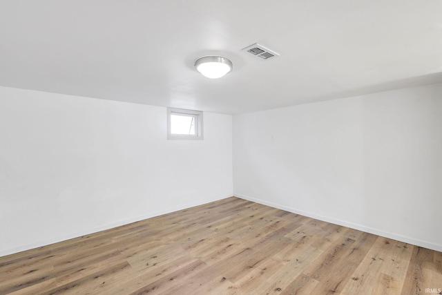 basement featuring visible vents, baseboards, and light wood-style floors