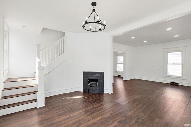 unfurnished living room featuring stairway, wood finished floors, visible vents, an inviting chandelier, and recessed lighting