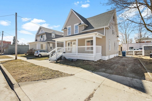 bungalow-style home with covered porch and a shingled roof