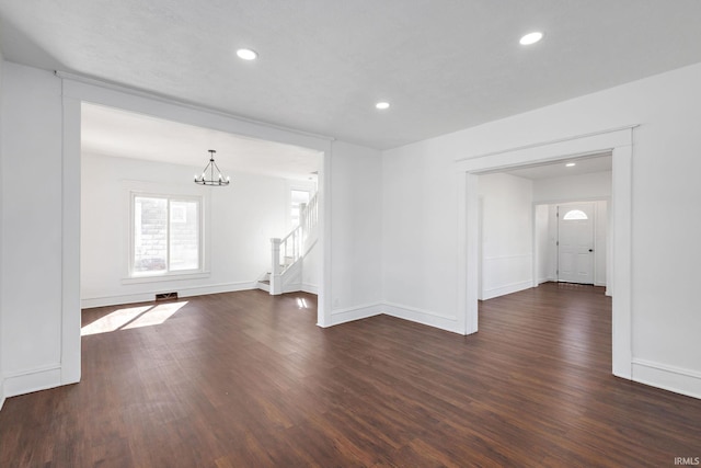 unfurnished room with stairway, a notable chandelier, recessed lighting, and dark wood-style flooring