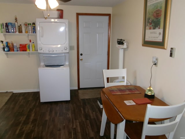 laundry room with dark wood-type flooring, stacked washer and clothes dryer, baseboards, ceiling fan, and laundry area