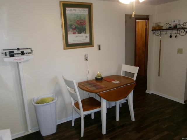 dining area with dark wood finished floors and baseboards