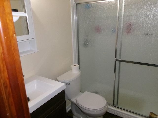 full bathroom featuring vanity, a shower stall, and toilet