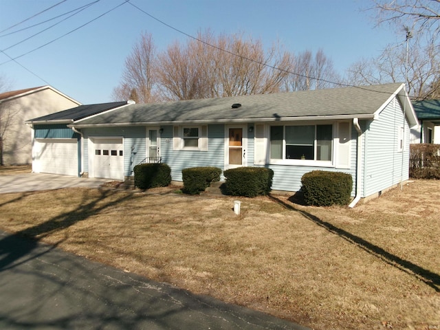 ranch-style home featuring a front lawn, an attached garage, and driveway