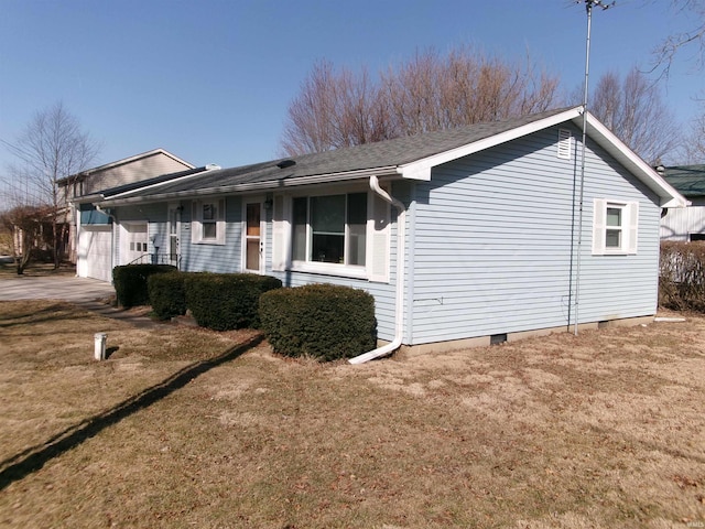 view of side of home with crawl space, a lawn, driveway, and a garage